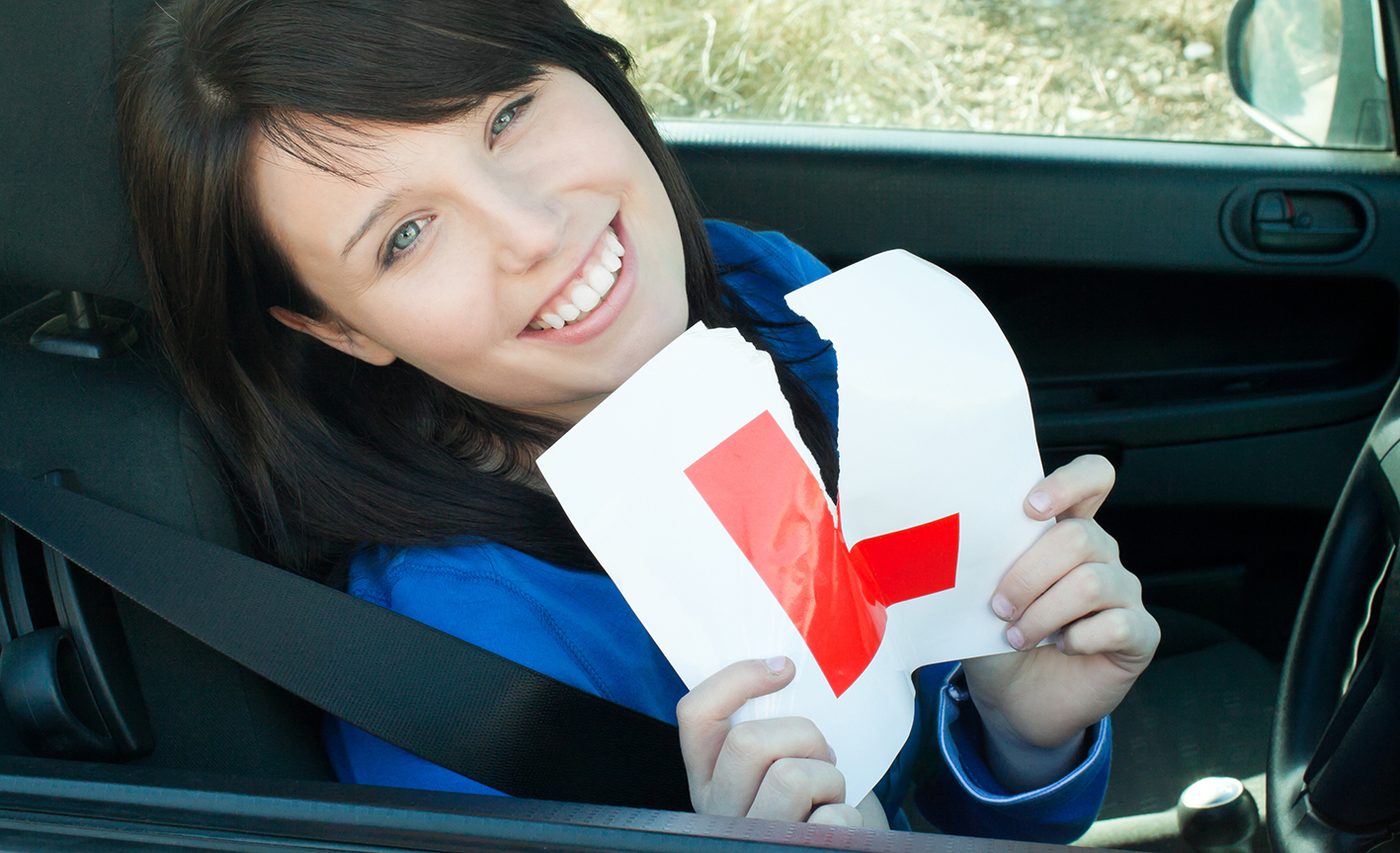 Delighted learner driver tearing up her L plate after passing her driving test